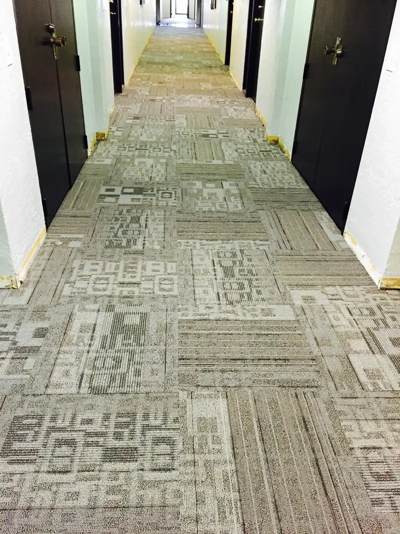 New commercial carpet tile running the length of an apartment building corridor
