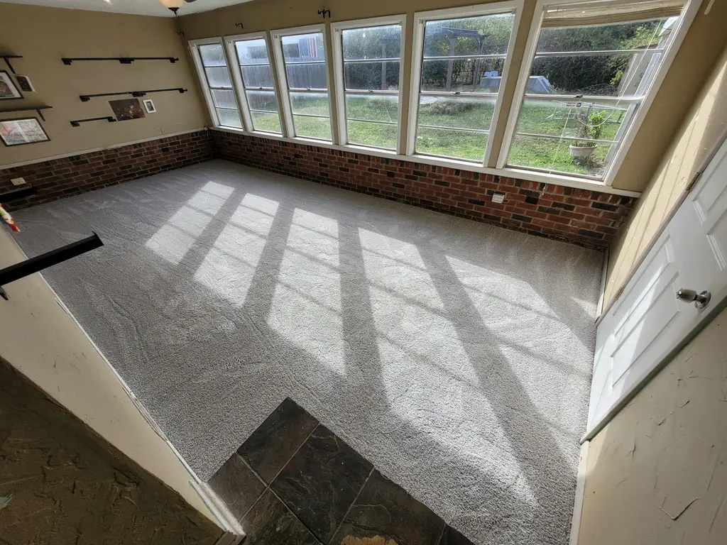 Freshly cleaned carpet in a brick-silled sunroom with daylight raking across the pile